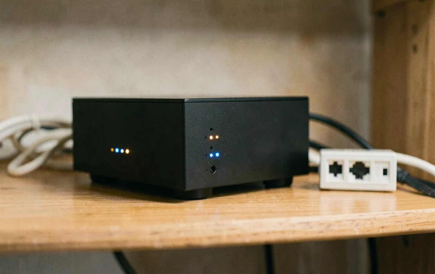 Pequeño servidor doméstico con luces de estado junto a un switch de red